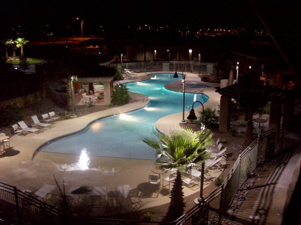 long, curving and abstract shaped pool, at night, on a commercial property