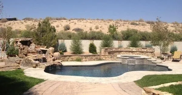 Freeform pool with rock waterfall in a desert backyard in New Mexico